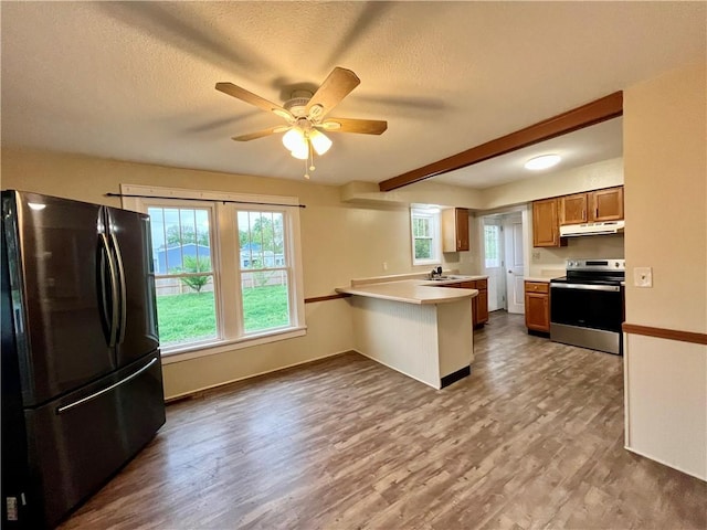 605 N 15th St, Mattoon, IL 61938 - kitchen with wood finished floors, stainless steel range with electric stovetop, freestanding refrigerator, a peninsula, and under cabinet range hood