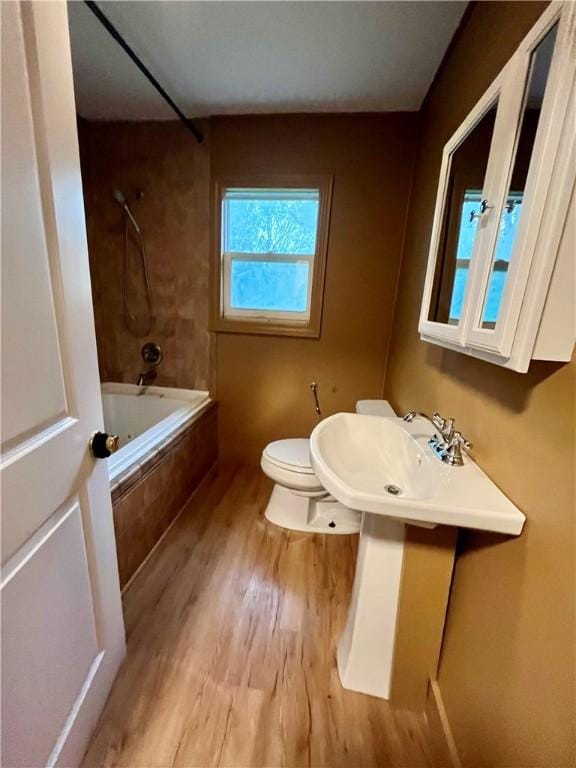 605 N 15th St, Mattoon, IL 61938 - full bath with a sink, wood finished floors, tiled shower / bath combo, and toilet