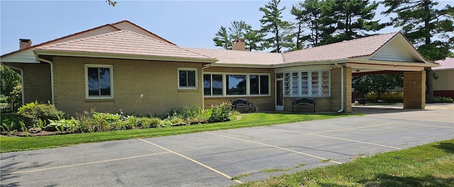 back of property featuring a carport and a yard