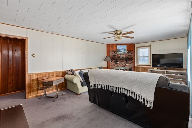 carpeted bedroom with a brick fireplace and ceiling fan