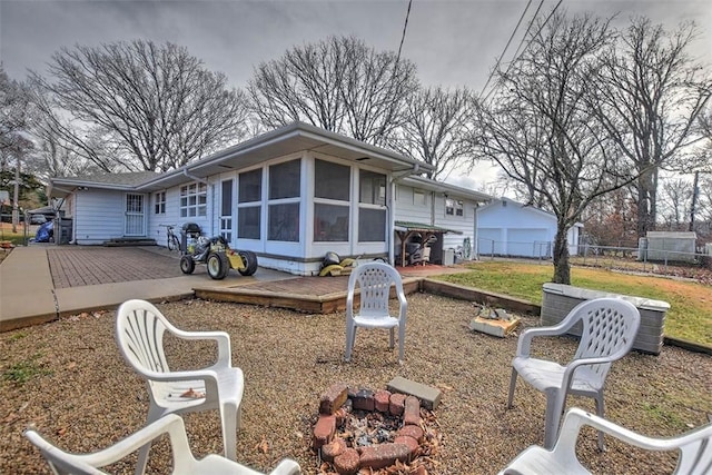 exterior space with a sunroom, a fire pit, and a deck