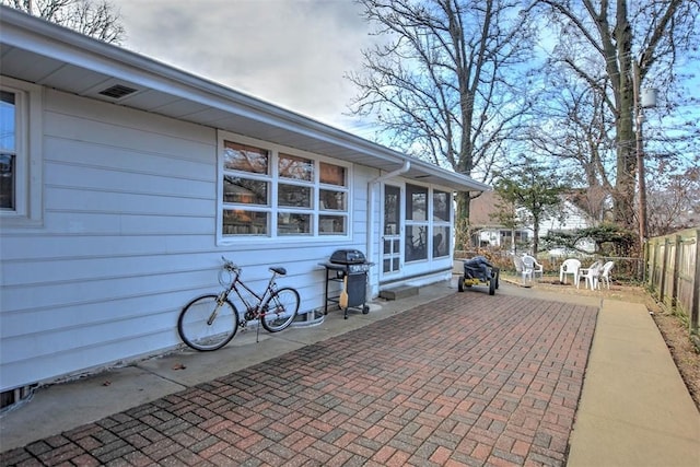 view of patio with grilling area and a sunroom