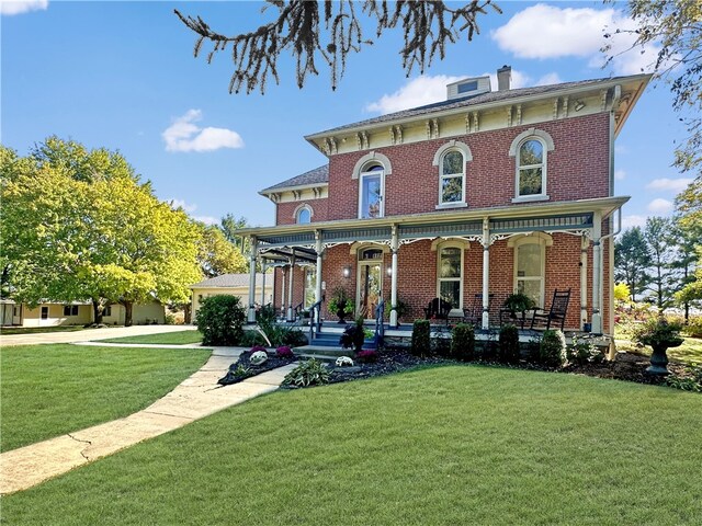 italianate-style house with a porch and a front yard