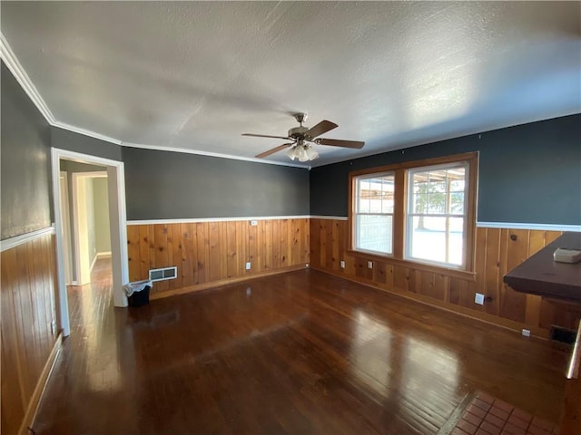 unfurnished room featuring a textured ceiling, ornamental molding, ceiling fan, and dark hardwood / wood-style floors