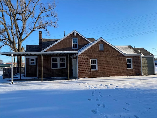 view of snow covered back of property