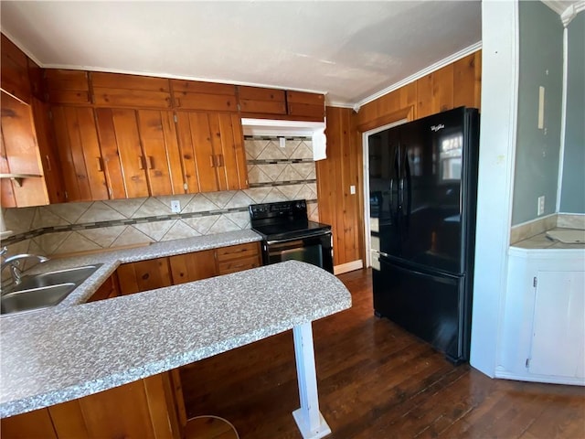 kitchen featuring sink, kitchen peninsula, backsplash, dark hardwood / wood-style flooring, and black appliances