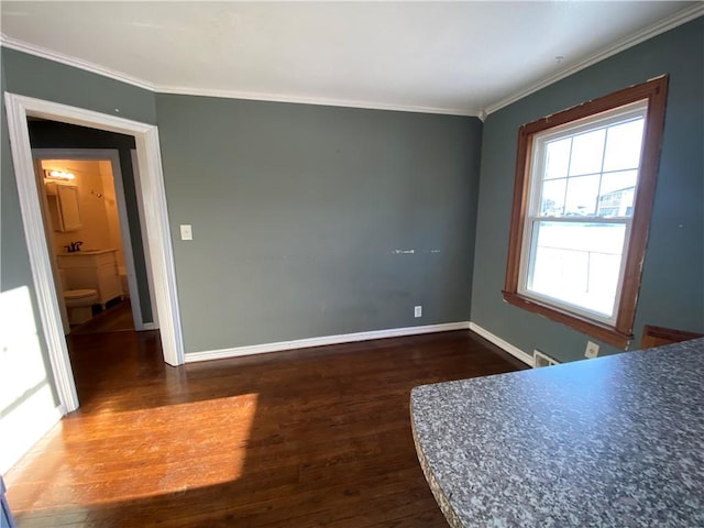 unfurnished bedroom with sink, ensuite bathroom, ornamental molding, and dark wood-type flooring