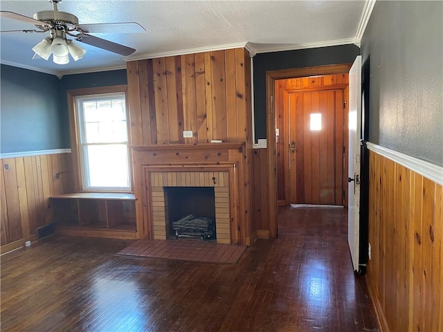 unfurnished living room featuring a fireplace, ornamental molding, and ceiling fan