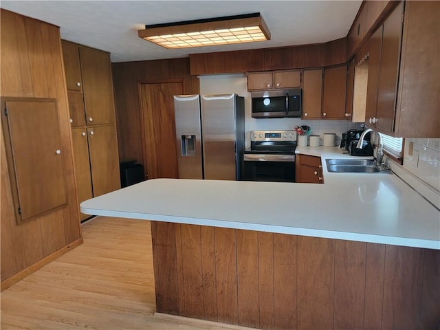 505 W N 9th St, Shelbyville, IL 62565 - kitchen featuring stainless steel appliances, a peninsula, light countertops, light wood finished floors, and decorative backsplash