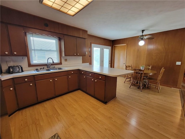 505 W N 9th St, Shelbyville, IL 62565 - kitchen with a peninsula, light countertops, light wood finished floors, a ceiling fan, and wood walls