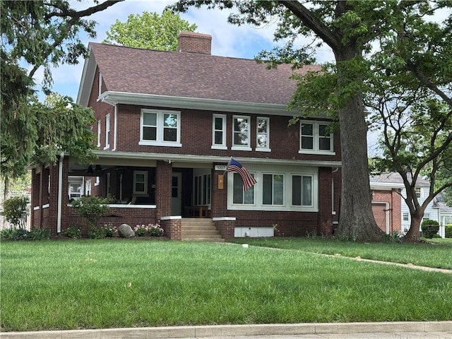 1007 10th St, Charleston, IL 61920 - view of front of house with brick siding, a front lawn, a chimney, and a porch
