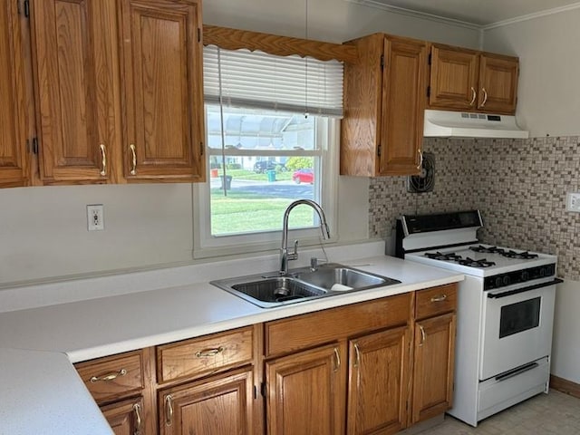 1216 Lawn Dr, Mattoon, IL 61938 - kitchen with white gas stove, under cabinet range hood, brown cabinets, light countertops, and crown molding