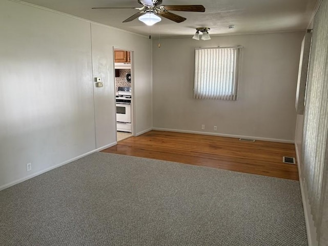 1216 Lawn Dr, Mattoon, IL 61938 - unfurnished room featuring ceiling fan, carpet, crown molding, and wood finished floors