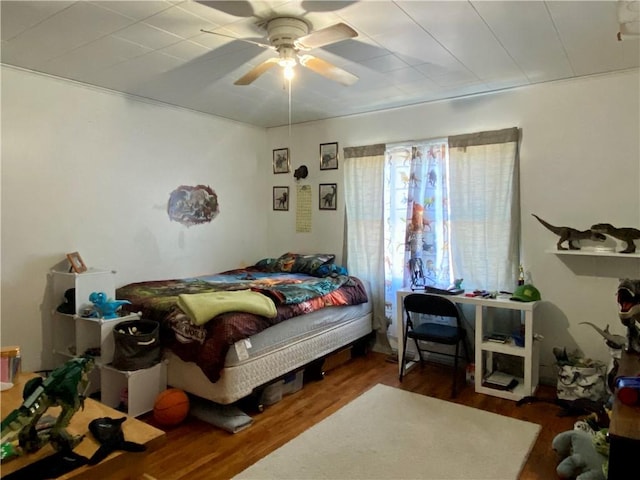 bedroom with a ceiling fan and wood finished floors