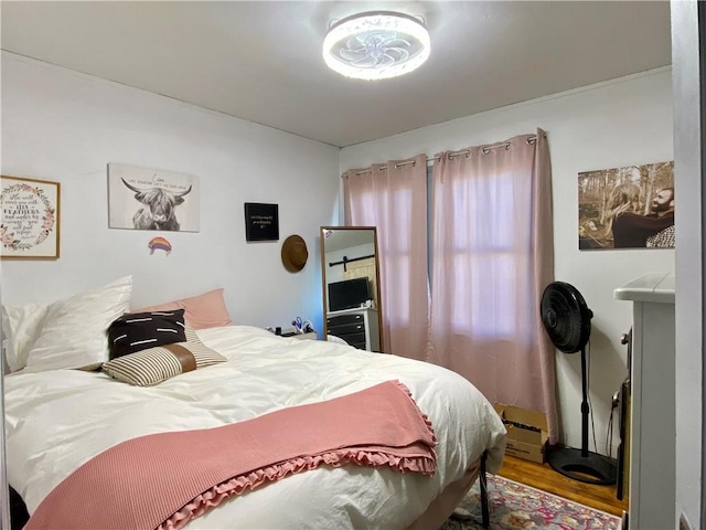 bedroom with baseboard heating and wood finished floors