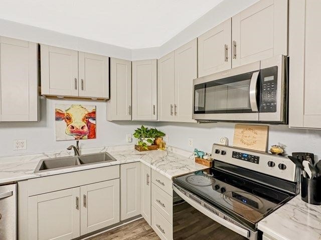 525 N 7th St, Charleston, IL 61920 - kitchen with stainless steel appliances, light wood-type flooring, and light stone counters
