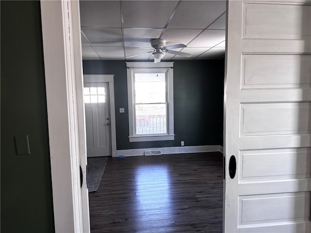 entryway featuring a drop ceiling, dark wood-type flooring, visible vents, a ceiling fan, and baseboards