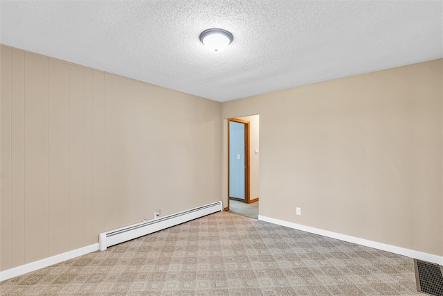 carpeted spare room with a baseboard radiator and a textured ceiling