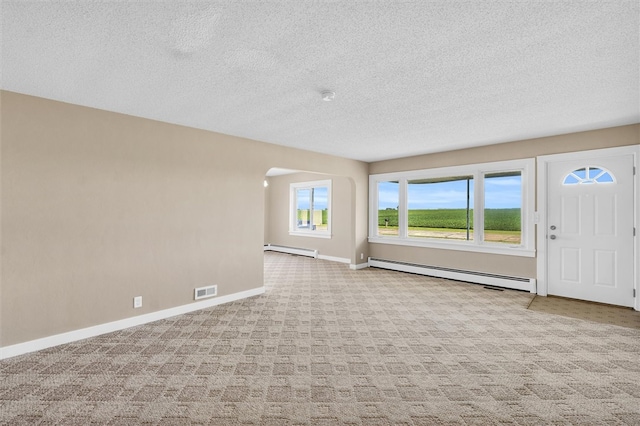 interior space featuring baseboard heating, light colored carpet, and a textured ceiling