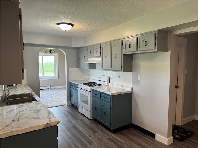 kitchen featuring decorative backsplash, dark hardwood / wood-style flooring, white gas range, a baseboard heating unit, and sink