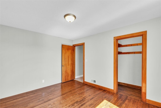 unfurnished bedroom featuring a closet and hardwood / wood-style floors