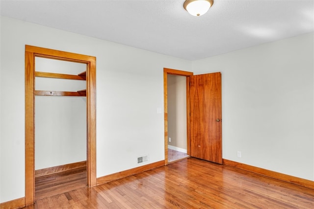 unfurnished bedroom with a closet and wood-type flooring