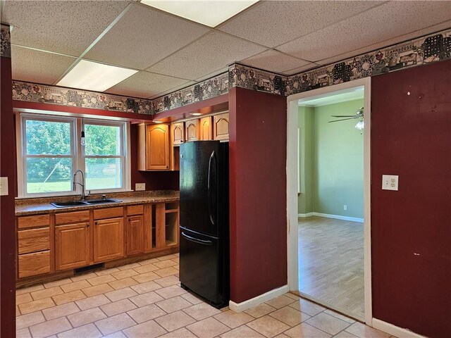 301 S Meridian St, Toledo, IL 62468 - kitchen with freestanding refrigerator, a paneled ceiling, dark countertops, brown cabinetry, and light tile patterned floors