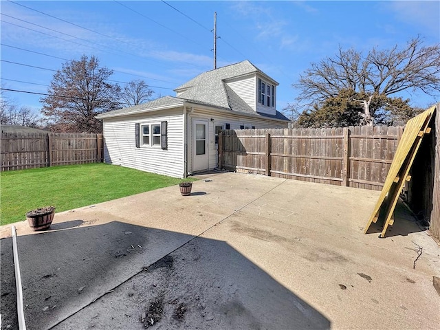 back of house with a patio area, a fenced backyard, a lawn, and roof with shingles