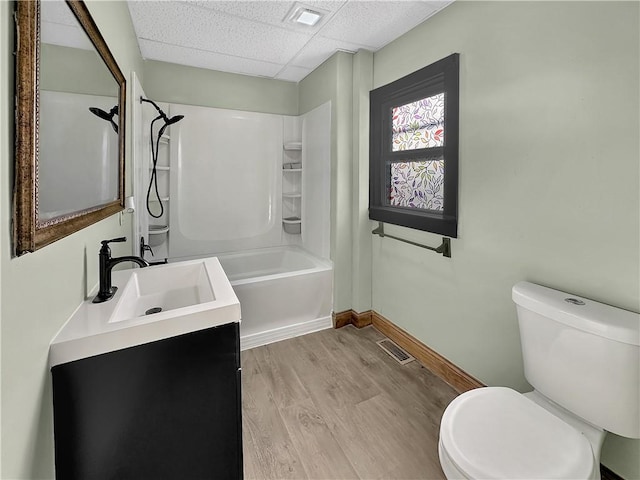 bathroom featuring visible vents, toilet, a drop ceiling, and wood finished floors