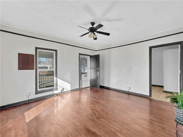 interior space featuring a ceiling fan, baseboards, and wood finished floors