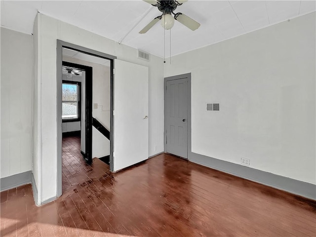 spare room featuring ceiling fan, visible vents, and wood finished floors