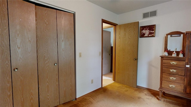 unfurnished bedroom with light carpet and a closet