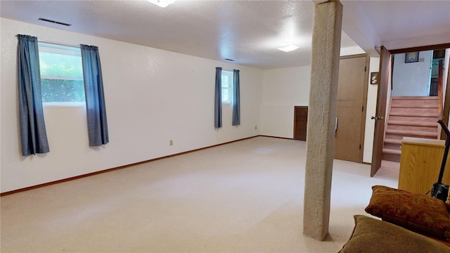 unfurnished room with light colored carpet and a textured ceiling