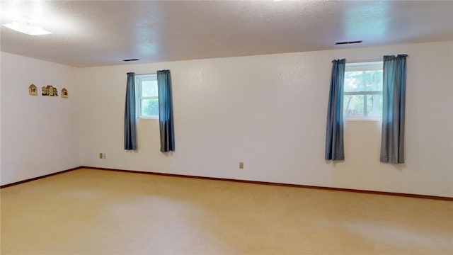 carpeted empty room with a textured ceiling