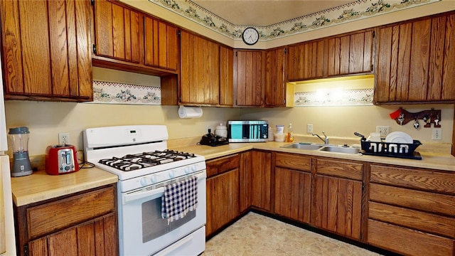 kitchen featuring sink and white range with gas cooktop