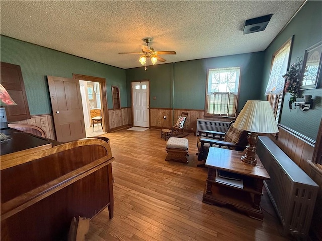 27288 State Highway 16, Ashmore, IL 61912 - living area featuring a wainscoted wall, hardwood / wood-style floors, a textured ceiling, ceiling fan, and wooden walls