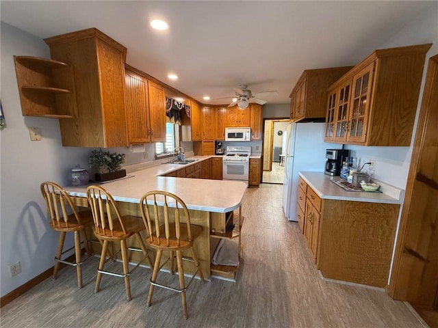 27288 State Highway 16, Ashmore, IL 61912 - kitchen featuring white appliances, a peninsula, brown cabinetry, light countertops, and recessed lighting