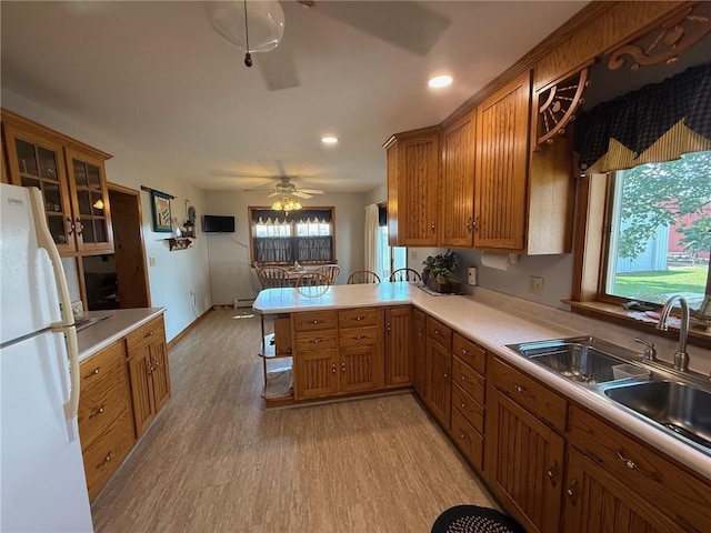 27288 State Highway 16, Ashmore, IL 61912 - kitchen featuring freestanding refrigerator, brown cabinets, a peninsula, light wood finished floors, and recessed lighting