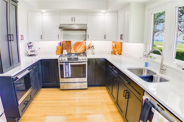 400 Country Club Rd, Mattoon, IL 61938 - kitchen featuring stainless steel appliances, under cabinet range hood, healthy amount of natural light, white cabinetry, and recessed lighting