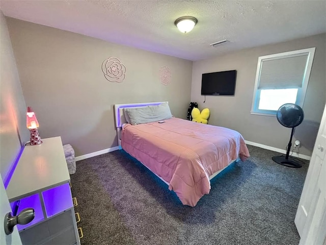 bedroom with a textured ceiling, carpet, and baseboards