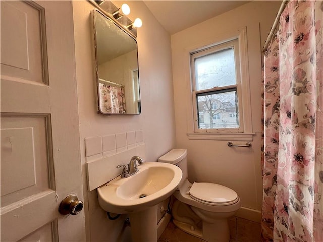 bathroom with a shower with shower curtain, a sink, and toilet