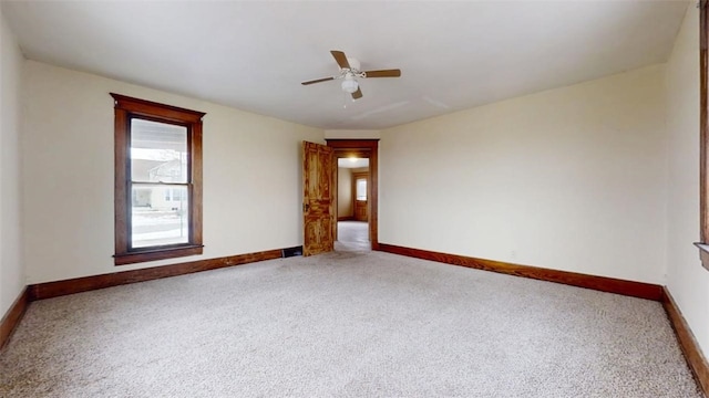 unfurnished room featuring a ceiling fan, carpet, and baseboards