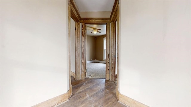 hall with wood-type flooring and baseboards