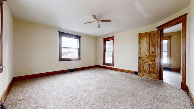 unfurnished room with carpet floors, baseboards, and a ceiling fan