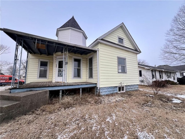 rear view of property featuring covered porch