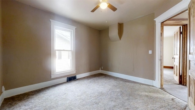 spare room featuring a ceiling fan, visible vents, baseboards, and carpet flooring