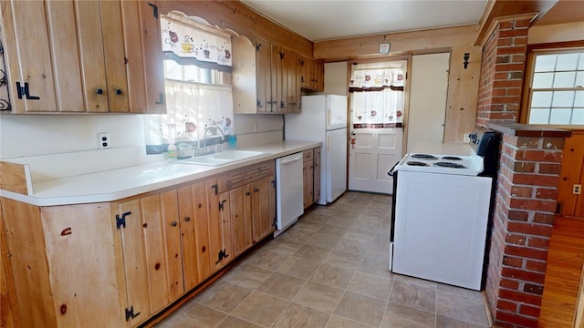 kitchen featuring light countertops, white appliances, and a sink