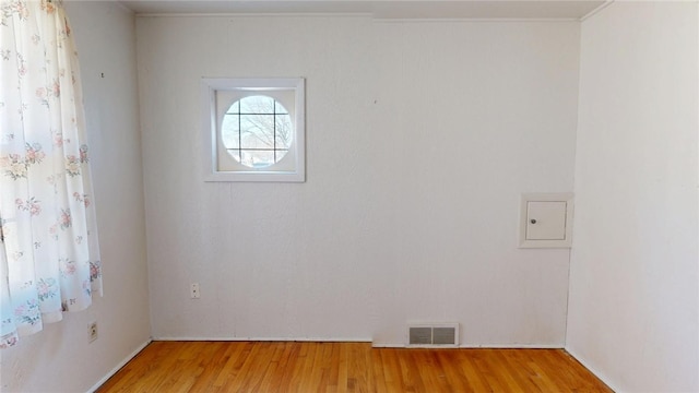 empty room featuring wood finished floors and visible vents