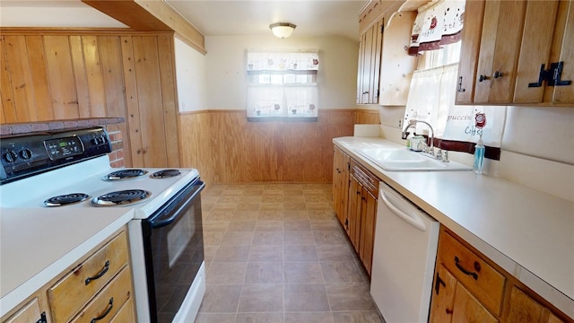 kitchen featuring electric range oven, wainscoting, a sink, white dishwasher, and wood walls