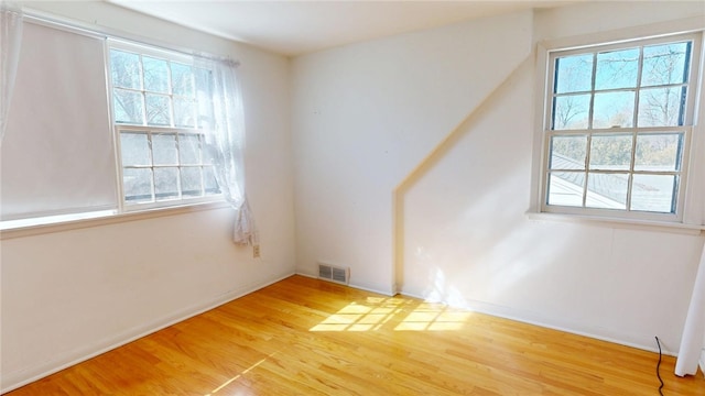 unfurnished room featuring visible vents and light wood-style flooring